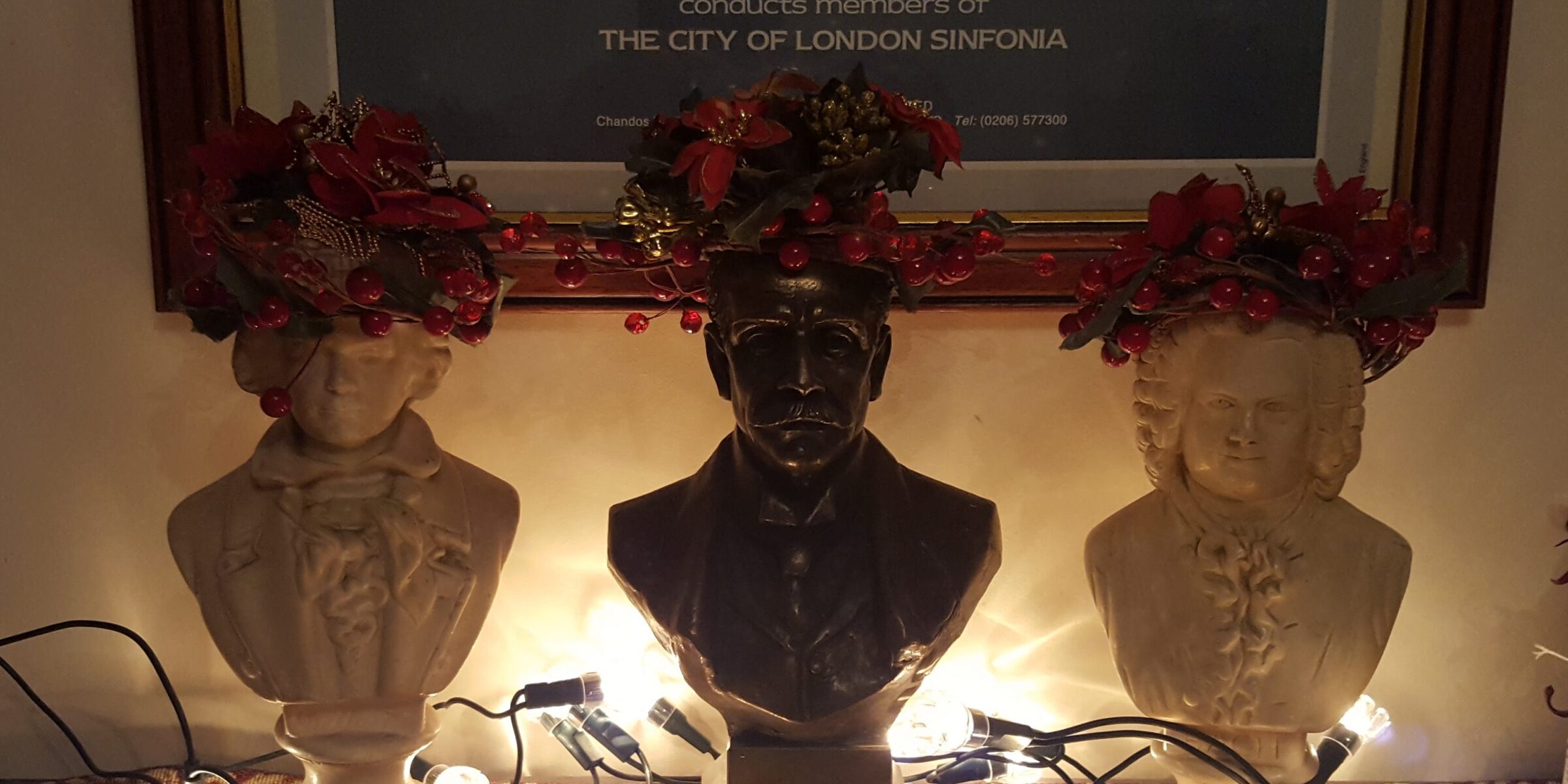 Busts of composers wearing Christmas wreaths on their heads